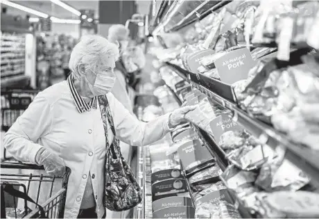  ?? ALEXANDRA WIMLEY/PITTSBURGH POST-GAZETTE 2020 ?? A woman shops for meat at the Giant Eagle grocery store in Ross Township, Pennsylvan­ia.
