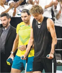  ?? CHRISTOPHE ENA AP ?? Rafael Nadal walks alongside Alexander Zverev who retired with an ankle injury in their semifinal match at the French Open in Roland Garros stadium.