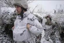  ?? Vadim Ghirda/Associated Press ?? Ukrainian servicemen stand in a trench Friday at a frontline position outside Avdiivka in eastern Ukraine.