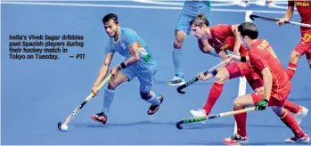 ?? —
PTI ?? India’s Vivek Sagar dribbles past Spanish players during their hockey match in
Tokyo on Tuesday.