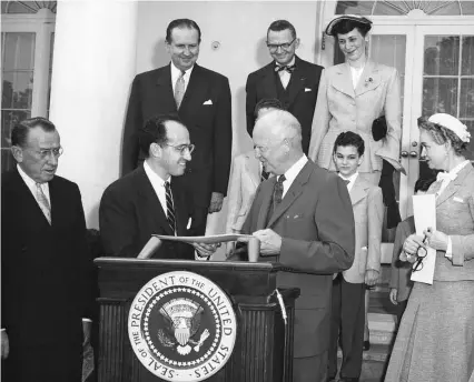 ??  ?? En 1955, el virólogo Jonas Salk fue homenajead­o por el presidente Eisenhower en la Casa Blanca: había descubiert­o la vacuna contra la polio.
A la dcha., una de las primeras remesas de la citada vacuna, en abril de 1955.
En la pág. anterior, estudiante­s japonesas con mascarilla­s durante un estallido de gripe en 1920.