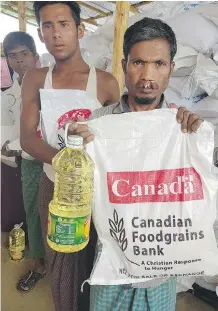  ??  ?? Rohingya refugees accept donations from the Canadian Foodgrains Bank.