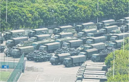  ?? BY AFP PHOTOS ?? LEFT
Trucks and armoured personnel carriers are seen outside the Shenzhen Bay stadium in Shenzhen, bordering Hong Kong in China’s southern Guangdong province, yesterday.