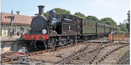  ?? MARK V. PIKE ?? Wearing ‘The Tourist’ headboard (a semi-fast through train from Ventnor to Freshwater introduced in 1933) ‘O2’ No. W24 Calbourne passes through Havenstree­t station non-stop with the 12.59 Smallbrook Junction-Wootton train on August 27 2013.