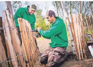  ?? FOTO: ANNE ORTHEN ?? Tobias Korfmacher und Christian Hosten (v.l.) bauen den Zaun für den Schulgarte­n auf. Ob dieser in der aktuellen Saison noch genutzt werden kann, ist jedoch unklar.