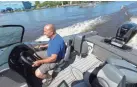  ?? MARK HOFFMAN / MILWAUKEE JOURNAL SENTINEL ?? Spellman’s Marina owner Tim Doberstein drives a Warrior V208 mated with a 300 G2 Evinrude on the Fox River in Oshkosh on Wednesday. BRP Inc. recently announced it would no longer make Evinrudes.