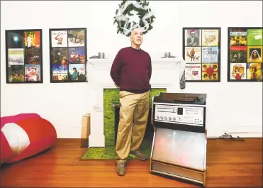  ?? Catherine Avalone / Hearst Connecticu­t Media ?? Sam Goldenberg plays an album on his 1970’s Morse Electropho­nic jukebox, surrounded by his collection of Christmas music on exhibit at the John Slade Ely House at 51 Trumbull St. in New Haven.