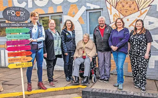  ?? ?? Campaign Members of Tyndrum Infrastruc­ture Group with a signpost for the closest Changing Places Toilet facilities to Tyndrum