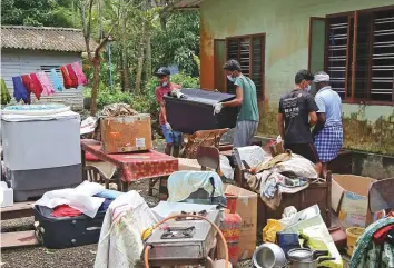  ?? Reuters ?? Volunteers gather household items outside a house in Kuttanad in Kerala’s Alappuzha district. Thousands of people are helping clear homes of mud following the devastatin­g floods.