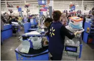  ?? PATRICK T. FALLON — BLOOMBERG ?? A cashier places items into a customer’s shopping cart at a Walmart Inc. store in Burbank, California.