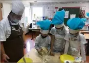  ?? (Photos J.-M.F.) ?? Après avoir fabriqué leur toque, les apprentis cuistots préparent le dessert du jour, des mendiants au chocolat.