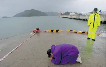  ?? AHN YOUNG-JOON/THE ASSOCIATED PRESS ?? A relative of a passenger aboard the sunken South Korean ferry prays as he awaits news on his missing loved one on Sunday.