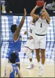  ?? Associated Press ?? WINNING SHOT —
Gonzaga guard Jalen Suggs (1) shoots over UCLA guard David Singleton (34) to win the game during overtime in a men’s Final Four NCAA basketball tournament semifinal game on Saturday. Gonzaga takes on Baylor in the championsh­ip game tonight.