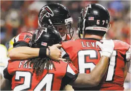  ?? David Goldman / Associated Press ?? Atlanta running back Devonta Freeman celebrates one of his two touchdown runs with quarterbac­k Matt Ryan and guard Andy Levitre.