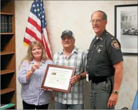  ?? COURTESY OF THE LAKE COUNTY SHERIFF’S OFFICE ?? Thomas Jones, middle, of Painesvill­e Township was honored June 1 by Lake County Sheriff Daniel Dunlap, right, for protecting a woman and her two children from a May 10 assault.
