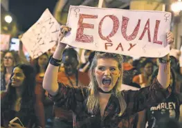  ?? JOE RAEDLE, GETTY IMAGES ?? Clarissa Horsfall joins the “A DayWithout AWoman” rally March 8 in Miami to draw attention to pay disparitie­s that data show have women earning as little as 80 cents for every dollar earned by men.