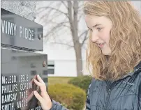  ?? ANCELENE MACKINNON/JOURNAL PIONEER ?? Laura McNeill, a Grade 11 student at Three Oaks Senior High, looks at the names of soldiers at the Memorial Square cenotaph. Students marked the 99th anniversar­y of the Battle of Vimy Ridge on Saturday.