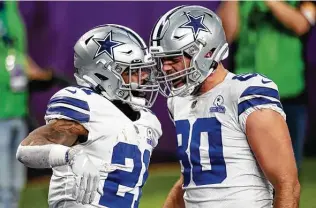  ?? David Berding / Associated Press ?? Ezekiel Elliott (21), celebratin­g his first-quarter TD catch with tight end Blake Bell, rushed for 103 yards Sunday and looked like the star running back the Cowboys are paying him to be.