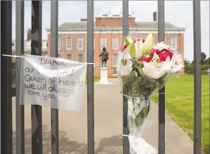  ?? The Associated Press ?? Messages and flowers are attached to the Golden Gates of Kensington Palace in London on Saturday, ahead of the 20th anniversar­y of Princess Diana’s death.