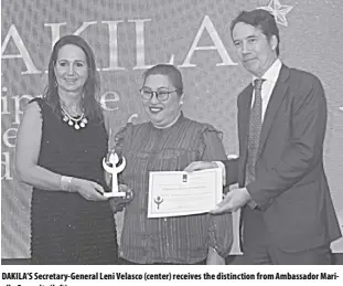  ?? ?? DAKILA’S Secretary-general Leni Velasco (center) receives the distinctio­n from Ambassador Marielle Geraedts (left).