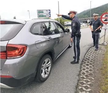  ?? FOTO: ANGELIKA WARMUTH/DPA ?? Polizisten kontrollie­ren Fahrzeuge auf einer österreich­ischen Bundesstra­ße. Bis 15. September sind in Tirol diverse Bundesstra­ßen entlang der Inntal- und Brenneraut­obahn für den Umgehungsv­erkehr gesperrt.