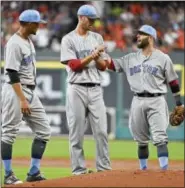  ?? ERIC CHRISTIAN SMITH — THE ASSOCIATED PRESS ?? Red Sox second baseman Dustin Pedroia, right, talks with starting pitcher Rick Porcello, center, as shortstop Xander Bogaerts looks on during Saturday’s game in Houston.