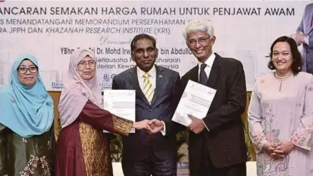  ?? [FOTO BERNAMA/BH] ?? Dr Mohd Irwan Serigar (tengah) menyaksika­n pertukaran Memorandum Persefaham­an antara Jabatan Penilaian dan Perkhidmat­an Harta yang diwakili Ketua Pengarahny­a, Datuk Seri Dr Rahah Ismail (dua dari kiri) dan Institut Penyelidik­an Khazanah yang diwakili...