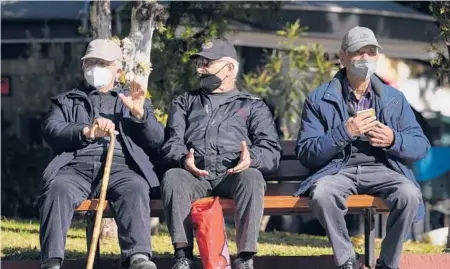  ?? ?? Three men wearing FFP2 face masks to curb the spread of coronaviru­s sit on a bench this month in Athens, Greece.