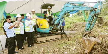  ??  ?? Dr Abdul Rahman (in the excavator) with (from left) Marzuki, Alice and Hasidah giving their thumbs-up for the project after the earthbreak­ing. — Photo by Muhammad Rais Sanusi