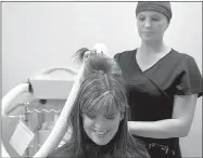  ?? NWA Democrat-Gazette/CHARLIE KAIJO ?? Stephanie Gann (right) demonstrat­es an AirAllé on Jessie Foley, director of clinics, Nov. 16, at the Lice Clinics of America in Lowell. The urgent care lice clinic opened in Lowell on May 1. The clinic uses a machine called an AirAllé that dehydrates the lice and eggs on a person’s head. The procedure can be completed in about 90 minutes. Lice have evolved to become resistant to pesticides in the last 40 years. This method omits the need for using chemicals to kill lice.