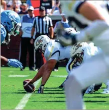  ?? DANNY KARNIK / Georgia Tech Athletics ?? Georgia Tech center Kenny Cooper lines up over the ball prior to a play during last Saturday’s game vs. North Carolina.