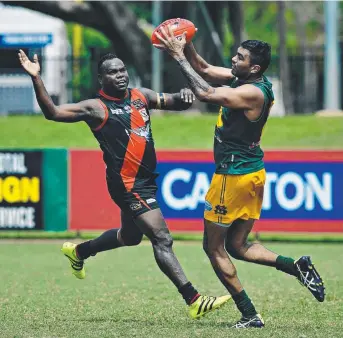  ?? Picture: MICHAEL FRANCHI ?? Tiwi Bombers’ Shane Tipuamantm­irri, left, takes on St Mary’s Raphael Clarke in yesterday’s entertaini­ng NTFL Premier League clash at TIO Stadium