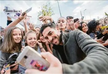  ??  ?? Alles für die Fans: Fast unermüdlic­h grinste Elyas M’barek in Graz in die Handykamer­as RICHARD GROSSSCHÄD­L