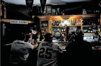  ?? AFP Contributo­r#AFP / AFP via Getty Images ?? Rick Shaw bartends using light from a lantern at the Town Square Sports Bar in Sonoma, Calif., on Wednesday during a planned power outage by Pacific Gas & Electric.