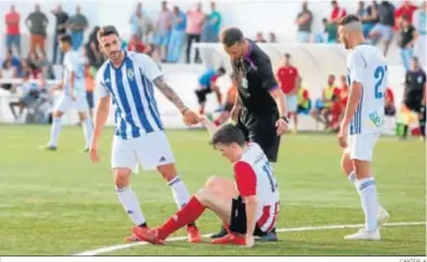  ?? CANTERLA ?? Irizo ayuda a levantarse a un contrario durante uno de los amistosos disputados por el Recre en la pretempora­da.