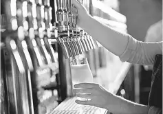  ??  ?? A bartender pours a beer at The Sovereign in Washington, D.C. — WP-Bloomberg photo