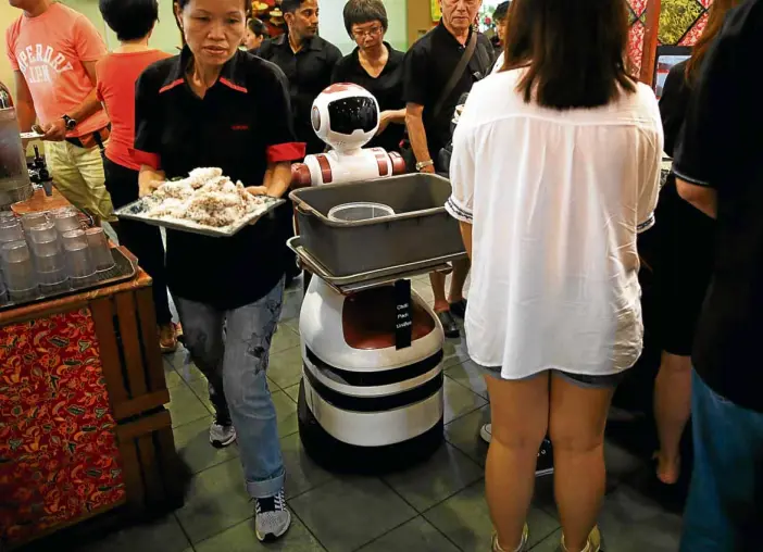  ?? REUTERS ?? A ROBOT navigates its way to collect dirty dishes at Chilli Padi Nonya Cafe in Singapore.