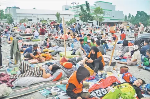  ?? — AFP photo ?? Medical team members help patients outside a hospital after an earthquake and a tsunami hit Palu.