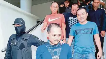  ??  ?? ANGGOTA polis mengiringi empat lelaki untuk sebutan semula di Mahkamah Sesyen Alor Setar.