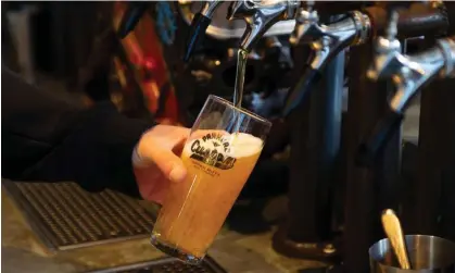  ?? Marty Melville/AFP/Getty Images ?? A New Zealand bartender pours a beer. Some drinks producers have slashed production owing to anational shortage of CO2. Photograph: