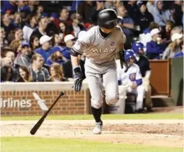  ??  ?? CHICAGO: Miami Marlins’ Ichiro Suzuki (51) runs to first base after hitting a single against the Chicago Cubs during the eighth inning of a baseball game, Monday, in Chicago. — AP