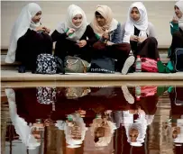  ?? AFP file ?? Young girls wearing hijab eat their lunch beside a pond at the V&amp;A Museum in London. —