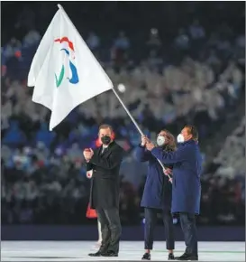  ?? CHLOE KNOTT / VIA AP ?? The vice-mayor of Milan and the mayor of Cortina d’Ampezzo (right) wave the Paralympic flag during the flag handover ceremony.