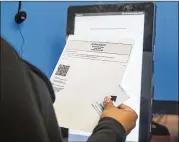  ?? ALYSSA POINTER / ALYSSA.POINTER@AJC.COM ?? Georgia’s new voting machines use printers to create a paper ballot that can be reviewed before it is tabulated by a scanner.