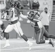  ?? Stephen Brashear / Associated Press ?? The Falcons’ Adrian Clayborn isn’t exactly speeding into the end zone, but he has enough juice to get past the Seahawks’ Ethan Pocic to score on a fumble return after Russell Wilson coughed up the ball.