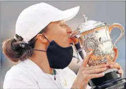  ??  ?? Iga Swiatek besa el trofeo de campeona de Roland Garros.