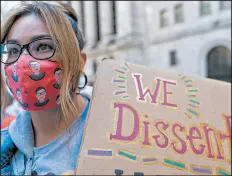  ?? MARY ALTAFFER/AP ?? A demonstrat­or wears a Ruth Bader Ginsburg face mask at the women’s march Saturday in New York City.