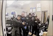  ?? MEDIAPROS 24/7 ?? An image from surveillan­ce video shows a Des Plaines police officer surrounded by fellow officers after the Des Plaines officer opened fire at a robbery suspect Nov. 19.