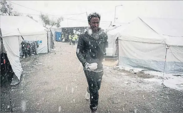  ?? STR / AFP ?? Un refugiado regresa a su tienda después de haber recogido una ración de comida en el campamento de Moria, en la isla griega de Lesbos