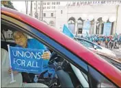  ?? Al Seib Los Angeles Times ?? DRIVER Carlos Martinez, who works for Uber and Lyft, joins ride-hail drivers rallying at City Hall.